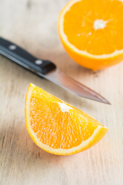 Una naranja cortada yace en una tabla
 - Foto, Imagen