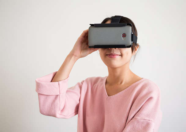 Женщина с помощью устройства виртуальной реальности
 - Фото, изображение