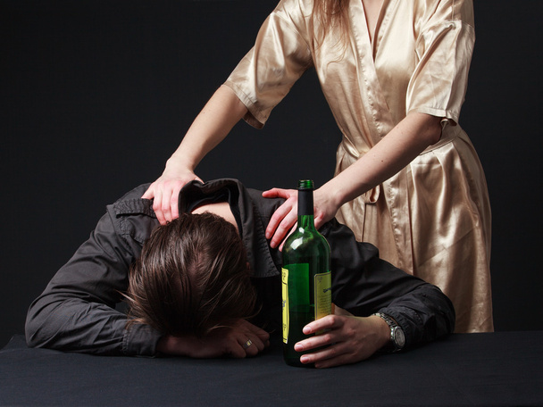 Alkoholismus. Betrunkener schläft mit Flasche auf dem Tisch - Foto, Bild