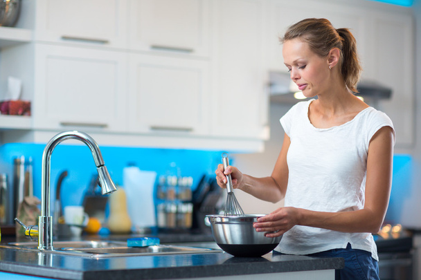Pretty, young woman in her modern, clean and bright kitchen - Foto, Bild