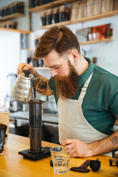 Barista pouring water on coffee ground with filter - Photo, image