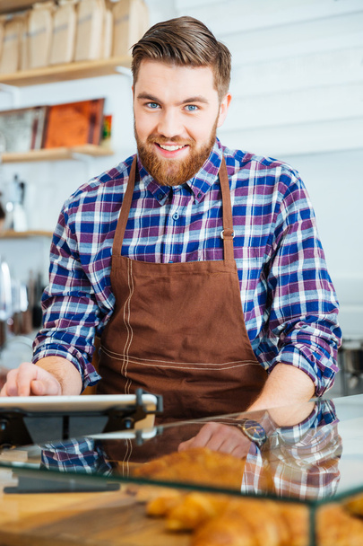Ritratto di barista barbuto felice al lavoro in caffetteria
 - Foto, immagini