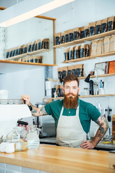Bearded barista with tattooed hands in coffee shop - Foto, imagen