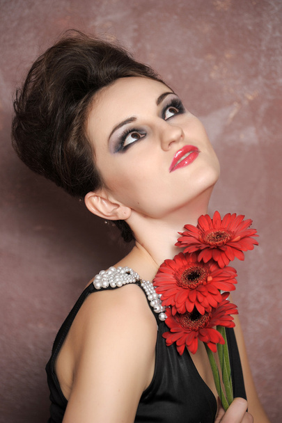 Attractive woman with red flowers - Foto, imagen