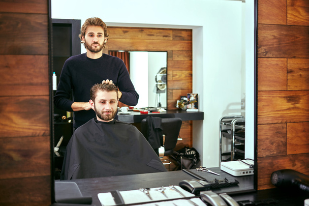 Friseur schneidet Männern im Schönheitssalon die Haare - Foto, Bild
