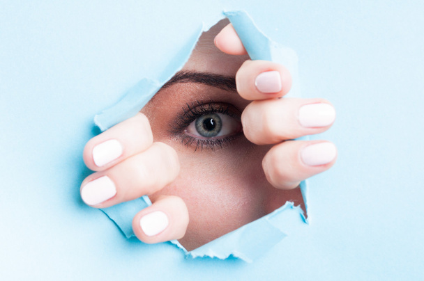 Frau blaues Auge mit Wimperntusche durch zerrissenes Brett - Foto, Bild