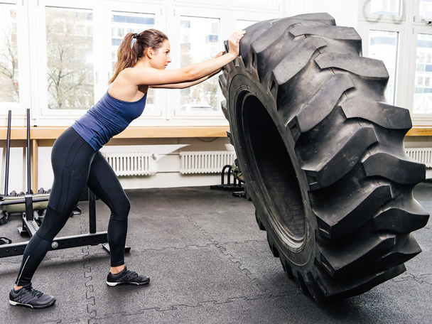Exercising with tire at crossfit gym - Valokuva, kuva