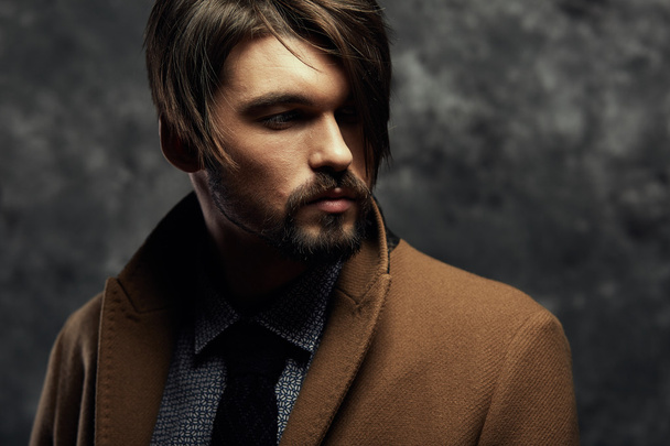 Young handsome man in a coat - studio male portrait - Zdjęcie, obraz