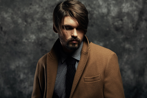 Young handsome man in a coat - studio male portrait - Photo, Image