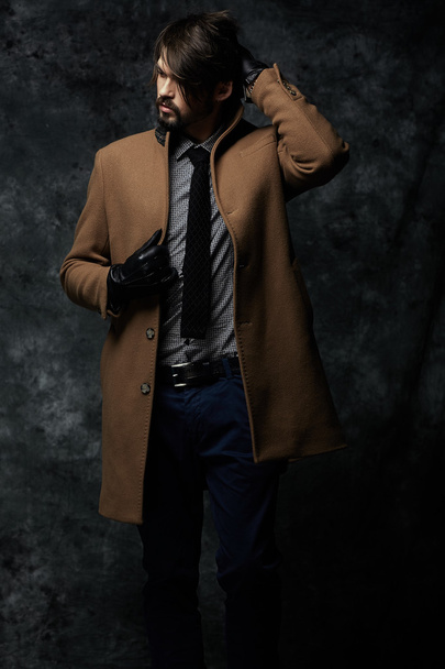 Young handsome man in a coat - studio male portrait - Foto, imagen