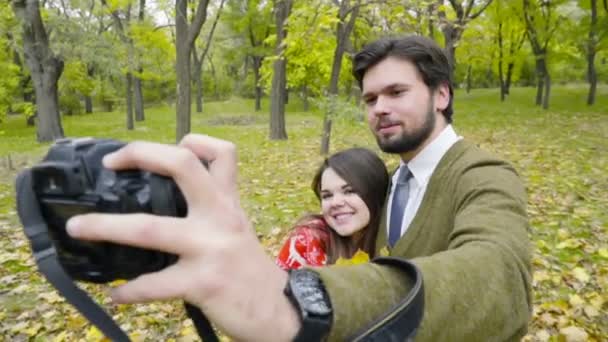 jovem casal fazendo selfie com uma câmera no parque de outono
 - Filmagem, Vídeo