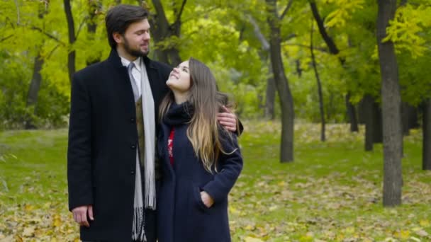 portrét mladé šťastnému páru nosí kabáty v podzimním parku - Záběry, video