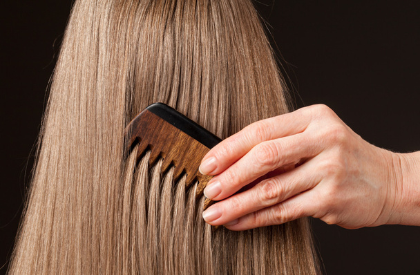 Female hand combing beautiful long hair - Zdjęcie, obraz