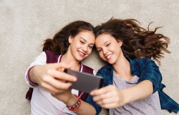 happy teenage girls on floor and taking selfie - Φωτογραφία, εικόνα