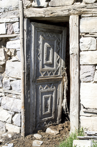 Ανοιχτή πόρτα από ξύλο με στολίδια για βουστάσιο στο παλιό πέτρινο σπίτι - Φωτογραφία, εικόνα
