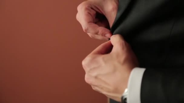 Man buttoning on a tuxedo - Záběry, video