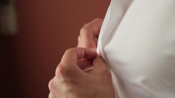 Uomo abbottonatura una camicia bianca
 - Filmati, video