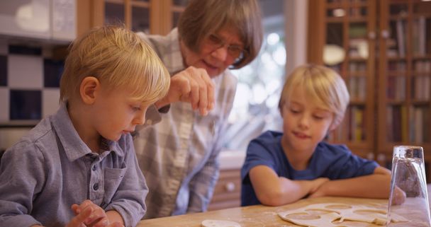 おばあちゃんと一緒にクッキーを作る 2 つの愛らしい白人の子供たち - 写真・画像