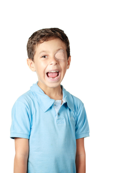 Niño con parche ocular aislado sobre fondo blanco
 - Foto, imagen