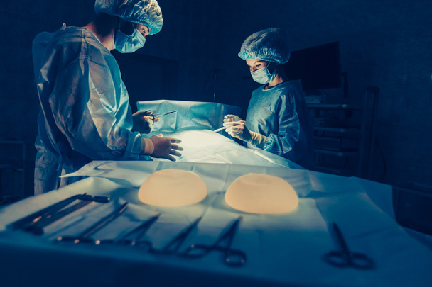 Surgeons team working with Monitoring of patient in surgical operating room. breast augmentation - Fotoğraf, Görsel