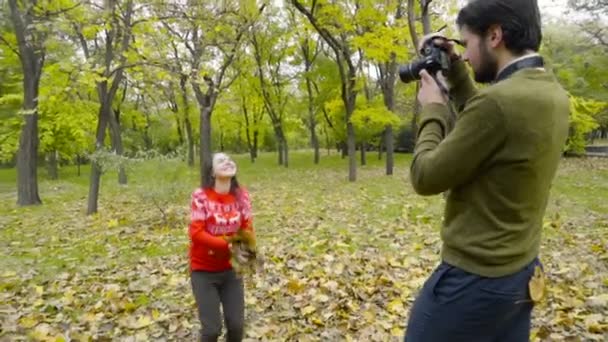 guy shooting his girlfriend throwing up some fallen leaves slow motion - Footage, Video