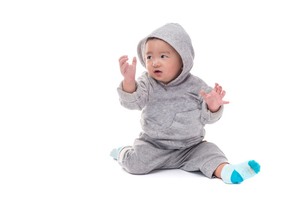 Asian baby in gray jacket with a hood, isolated on white backgro - Foto, afbeelding