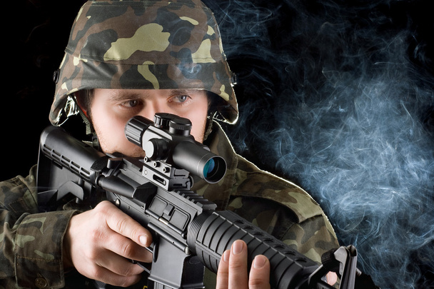 Soldier with the smoking gun. Closeup - Photo, Image
