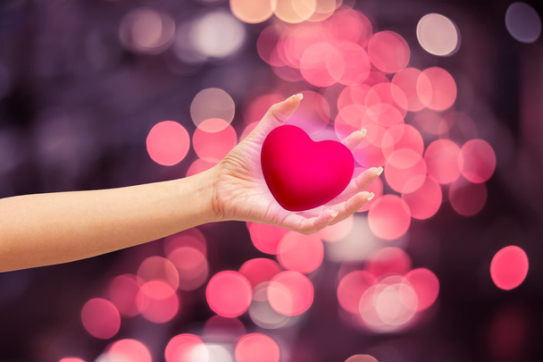Ροζ καρδιά στα χέρια σε φόντο φύση - Φωτογραφία, εικόνα