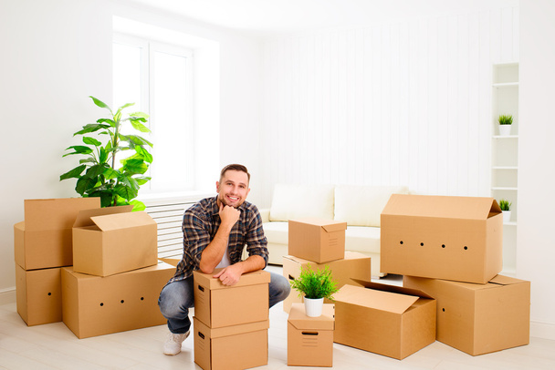 Переезд в новую квартиру. счастливый человек с картонными коробками
 - Фото, изображение