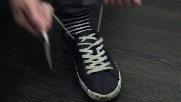 Mans hands tie white laces on left sport shoe. - Footage, Video