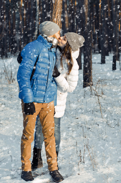 happy couple in love in winter forest - 写真・画像
