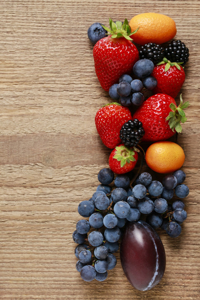 Truskawki, jagody, jeżyny, winogron i kumkwaty na  - Zdjęcie, obraz