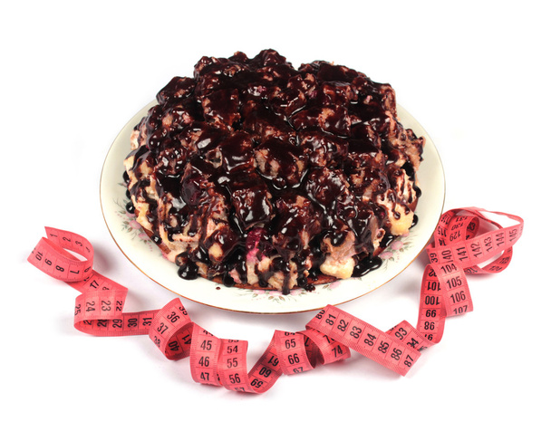 Wielki tort czekoladowy i elastycznego miernika na białym tle - Zdjęcie, obraz