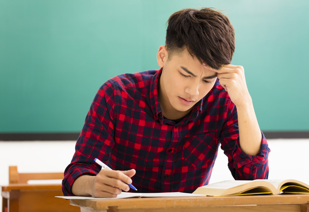 Stressed student  studying for exam in classroom - 写真・画像