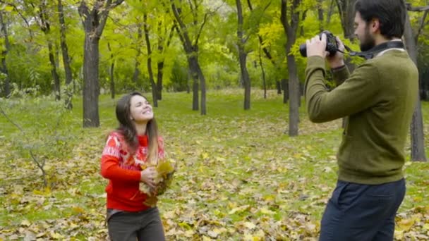 man schieten van zijn vriendin overgeven enkele gevallen bladeren slow-motion - Video