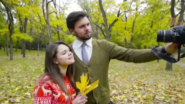 pareja joven haciendo selfie con una cámara en el parque de otoño
 - Imágenes, Vídeo
