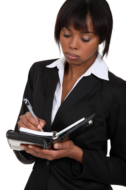 Fed-up businesswoman writing in her agenda - Foto, Imagem
