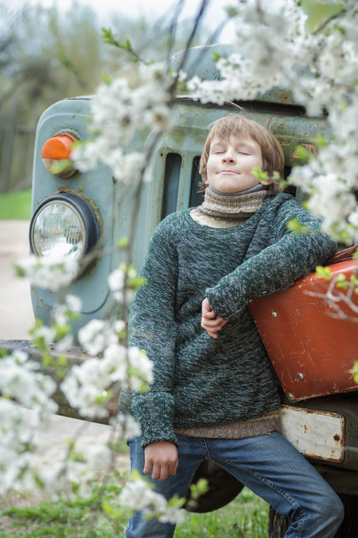 Soñando adolescente con los ojos cerrados usando punto melange suéter al aire libre con vintage russet maleta durante su viaje
 - Foto, Imagen