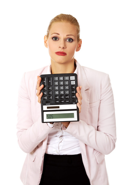 Worried business woman shows sos on calculator - Fotó, kép