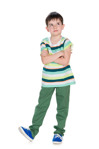 Cute little boy in a striped shirt looks up - Фото, изображение