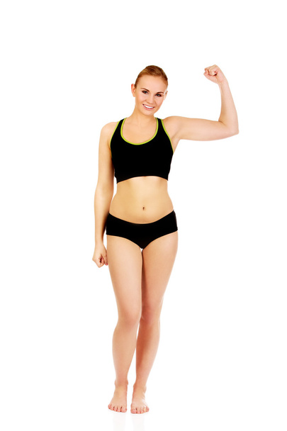 Young athletic woman showing muscles - Fotoğraf, Görsel