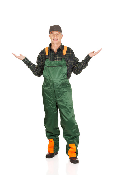 Gardener in uniform showing space with both hands - Photo, Image