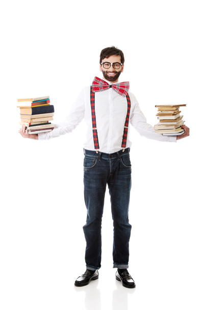 Man wearing suspenders with stack of books. - Foto, Imagem