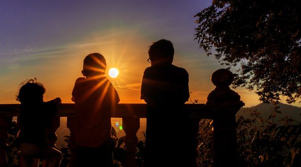 Σιλουέτα του κοιτάζοντας το ηλιοβασίλεμα με τον ήλιο φωτοβολίδες σε ένα o παιδιά - Φωτογραφία, εικόνα