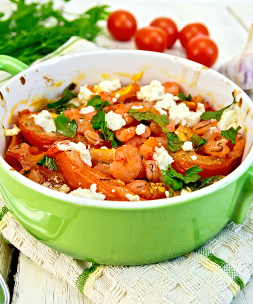 Shrimp and tomatoes with feta in green pan on napkin - Photo, Image