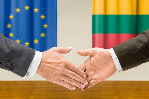 Representantes da UE e da Lituânia apertam a mão
 - Foto, Imagem
