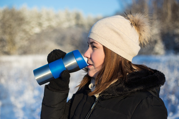 霜コンセプト - 冬の森で熱マグカップと美しい女性 - 写真・画像