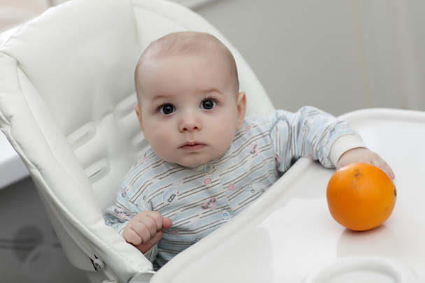 Serious baby with orange - Φωτογραφία, εικόνα