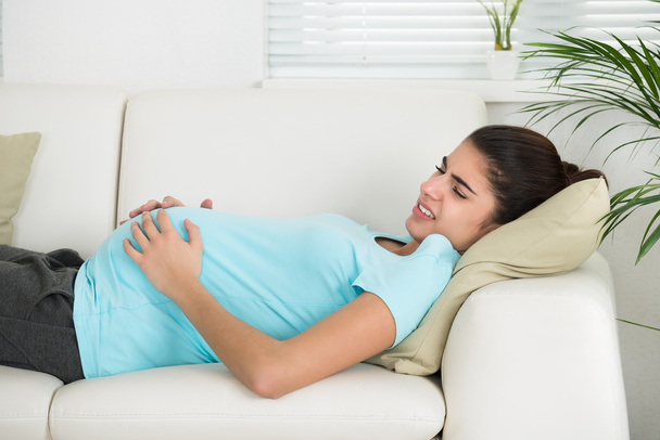 Mujer embarazada que sufre de dolor de estómago Ache
 - Foto, imagen