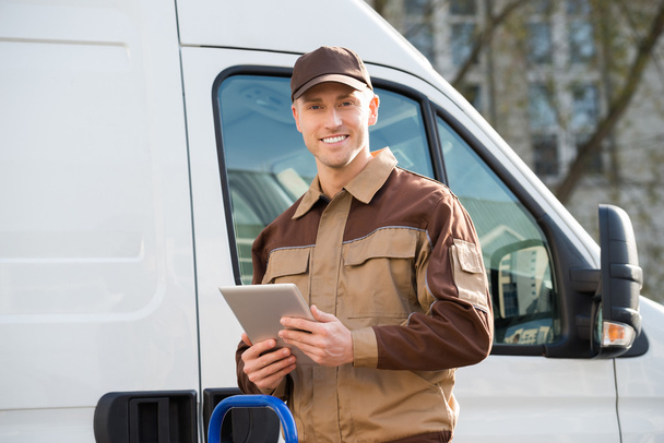 Smiling Delivery Man Holding Digital Tablet - Foto, immagini